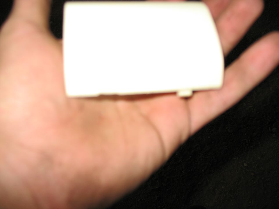 White plastic automotive part held in hand