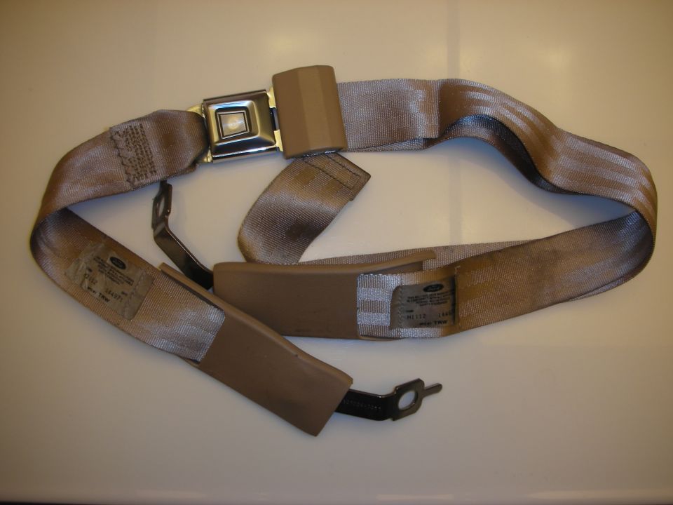 Tan automotive lap-and-shoulder seat belt with chrome buckle