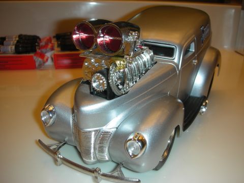 1998 Ford Crown Victoria - silver diecast panel-delivery hot rod model with a twin red-scoop blown engine, posed front-quarter on a shelf.