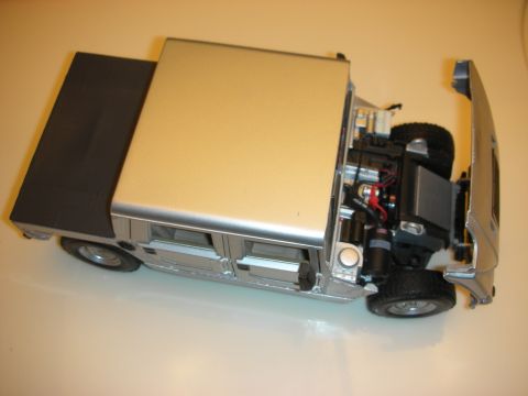 1998 Ford Crown Victoria - silver and gold die-cast model of a boxy 4x4 utility truck, hood up, showing detailed chassis and engine components.
