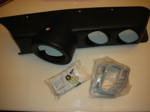 1998 Ford Crown Victoria - black molded dashboard gauge panel with three round gauge openings, shown with a hardware bag and mounting brackets.