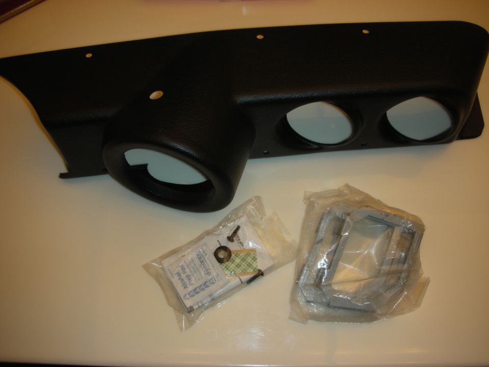 Black molded dash gauge panel with three round openings, hardware bag and brackets