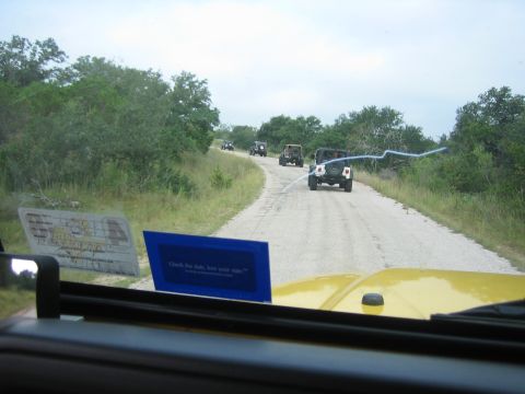 2001 Jeep Wrangler - A convoy of Jeeps travels down a dusty road, viewed from the perspective of a yellow Jeep.