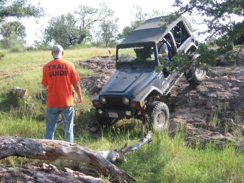 2001 Jeep Wrangler - Jeep Wrangler navigating a challenging off-road course with a trail guide present.