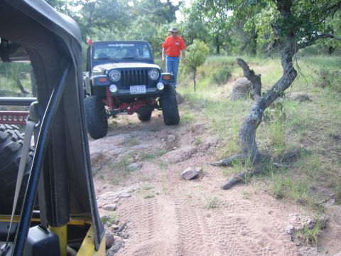 2001 Jeep Wrangler - Two Jeep Wranglers navigate a rocky, wooded trail during an off-road event.