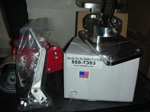 1998 Ford Crown Victoria - polished Steeda Tri-Ax shifter assembly displayed next to its retail box labeled 555-7353, made in the USA.