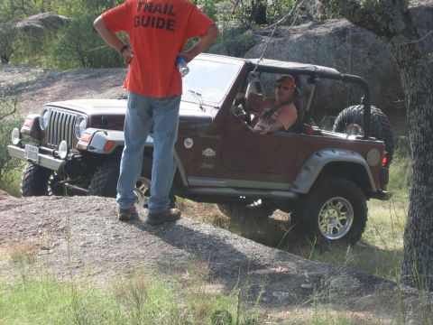 2001 Jeep Wrangler - A Jeep Wrangler navigates rocky terrain with a trail guide observing.