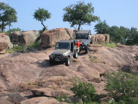 2001 Jeep Wrangler - Two Jeep Wranglers navigate a challenging rocky terrain during an off-road excursion.