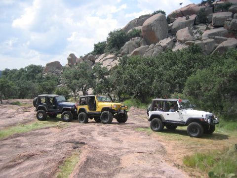 2001 Jeep Wrangler - Three Jeep Wranglers parked on a rocky hillside during an off-road event.
