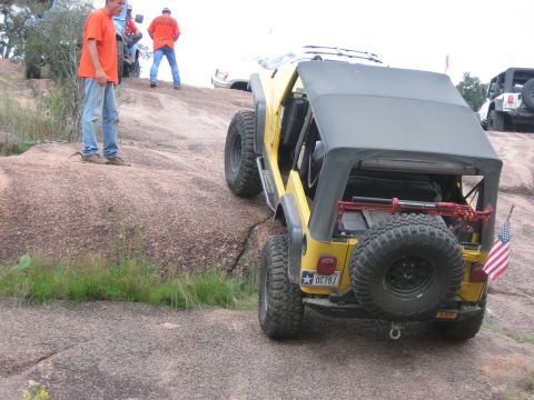 2001 Jeep Wrangler - Jeep Wrangler navigates a rocky trail with other vehicles and people around.