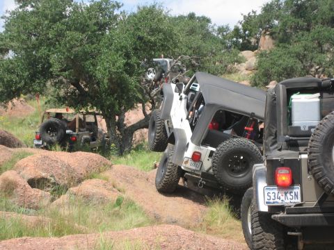 2001 Jeep Wrangler - Multiple Jeep Wranglers navigate a challenging rocky off-road course during an event.