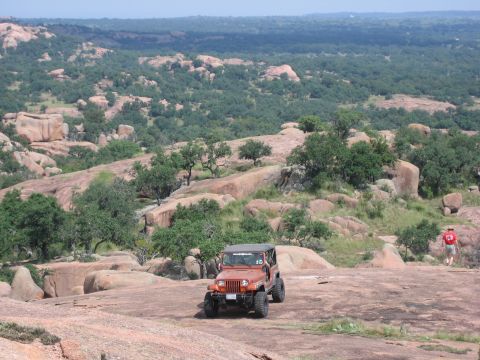 2001 Jeep Wrangler - A 2001 Jeep Wrangler is parked on a rocky landscape with a person walking in the distance.