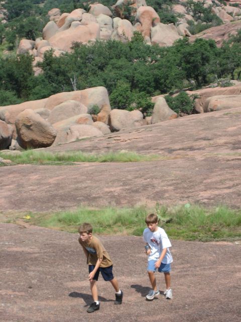 2001 Jeep Wrangler - Two boys explore a vast, rocky terrain with scattered vegetation and large boulders.