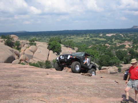2001 Jeep Wrangler - A Jeep Wrangler navigates a challenging rocky landscape under a partly cloudy sky.