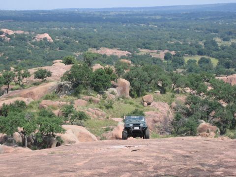 2001 Jeep Wrangler - Jeep Wrangler parked on a rocky outcrop overlooking a vast, tree-covered landscape.