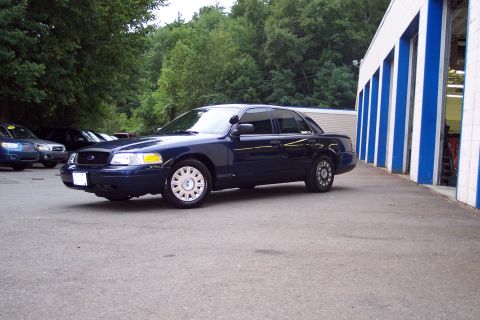 2001 Ford Crown Victoria - Dark blue 2001 Ford Crown Victoria parked outside a commercial building.