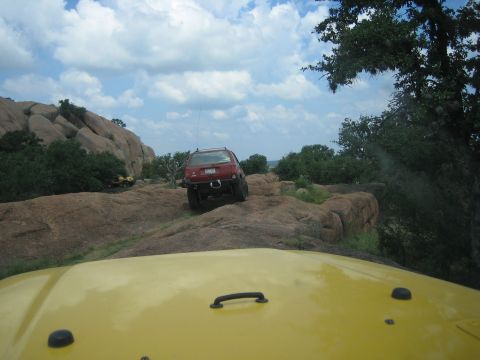2001 Jeep Wrangler - Two vehicles navigate a rocky, off-road trail under a cloudy sky.