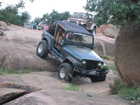 2001 Jeep Wrangler - Multiple Jeeps navigate a challenging rocky terrain during an off-road event.