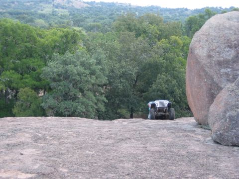 2001 Jeep Wrangler - A Jeep Wrangler is parked on a rocky surface with a dense forest in the distance.