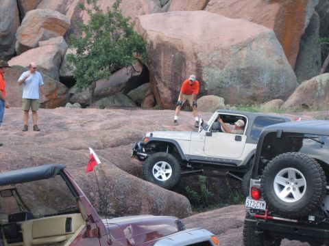 2001 Jeep Wrangler - Off-road vehicles navigate a rocky terrain with onlookers observing the challenging drive.