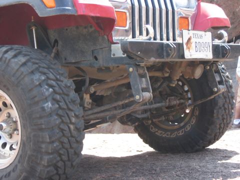 2001 Jeep Wrangler - Front view of a red Jeep Wrangler with prominent off-road tires and a Texas license plate.