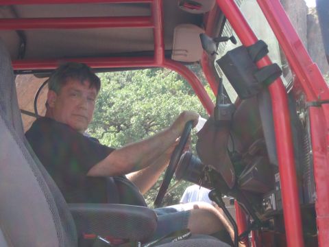 2001 Jeep Wrangler - Driver at the wheel of a red Jeep Wrangler, seen from the passenger seat.