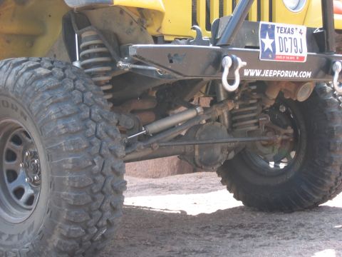 2001 Jeep Wrangler - This photo shows the rear suspension and tire of a yellow Jeep, with a Texas license plate.