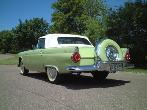 1956 Ford Thunderbird - A light green 1956 Ford Thunderbird convertible with a continental kit is parked on an asphalt road.
