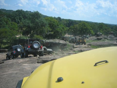 2001 Jeep Wrangler - Jeep convoy navigating a challenging rocky off-road course during a sunny day event.