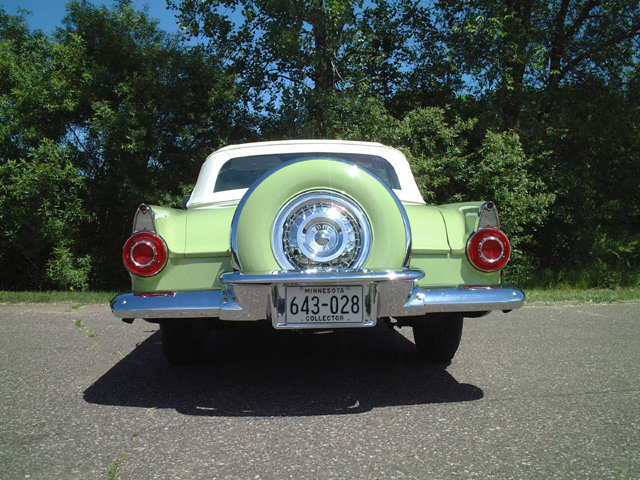 1956 Ford Thunderbird with continental kit, rear view. Green exterior, white top