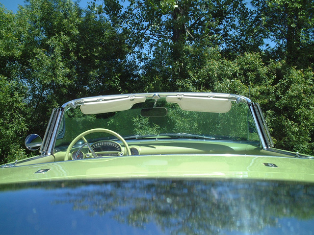 Green 1956 Ford Thunderbird convertible interior with a banjo steering wheel and dashboard, viewed from the front