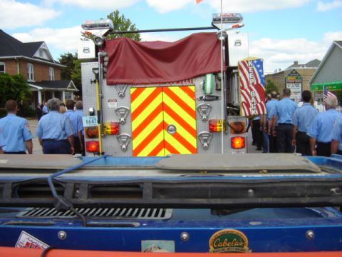 1992 Ford Bronco - Fire truck rear view with chevron doors and emergency lights. People in uniform are visible.