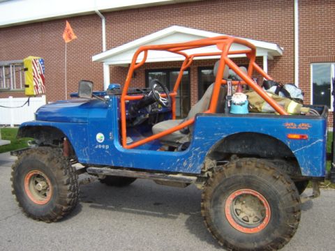 1992 Ford Bronco - Modified blue Jeep CJ with an aftermarket orange roll cage and off-road tires.