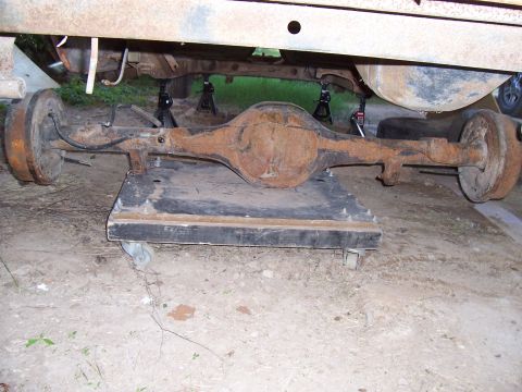 1955 Ford Customline - Rear axle assembly, likely from an older vehicle, sits on a wheeled dolly.