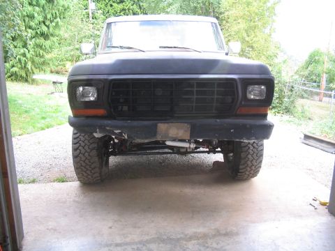 1979 Ford Bronco - Front view of a dark-colored truck, showing its grille and bumper with visible suspension components.