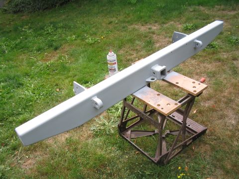 1979 Ford Bronco - A vehicle bumper is shown outdoors, painted gray and mounted on sawhorses.