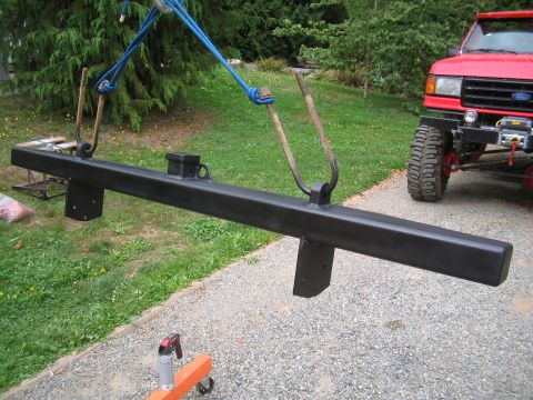 1979 Ford Bronco - Custom steel bumper is lifted by a crane, with a red Ford truck visible behind it.
