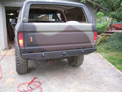 1979 Ford Bronco - The rear of a Ford Bronco, painted in camouflage, is shown with a custom aftermarket bumper.