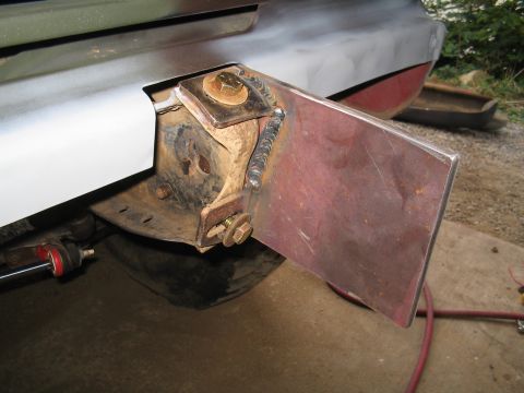 1979 Ford Bronco - Close-up of a bare-steel bumper mounting plate freshly welded to the frame horn of a truck, with a visible stack-of-dimes weld bead and gol…