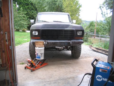 1979 Ford Bronco - Front view of a 1979 Ford Bronco undergoing maintenance, raised on a jack.