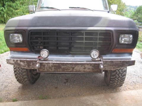 1979 Ford Bronco - Front view of a truck's grille and custom bumper with auxiliary lights.