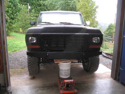 1979 Ford Bronco - The front of a black Ford Bronco is shown, supported by a jack and bucket inside a garage.