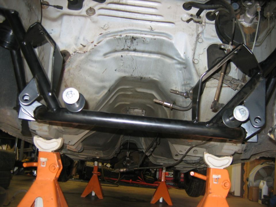 Underbody brace on a car supported by jack stands
