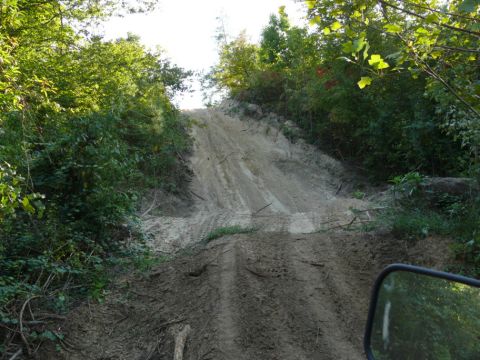 1988 Ford Bronco - Off-road trail on a sandy hill with tire tracks.