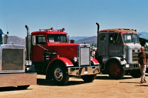 1981 Kenworth W900A - Three vintage trucks are parked side-by-side under a clear blue sky.
