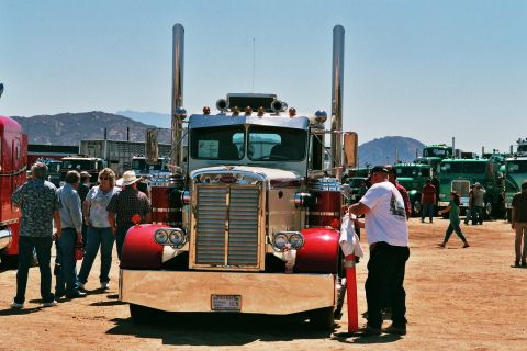 1981 Kenworth W900A - A classic Peterbilt 359 truck is displayed at an outdoor event, with other trucks visible in the background.