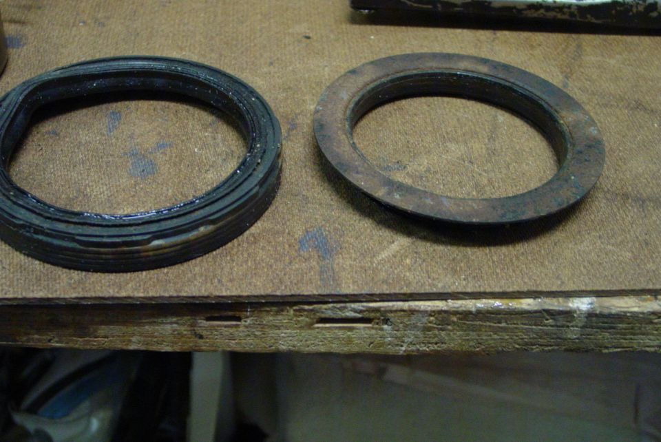 Two gaskets, one new and one rusted, on a workbench
