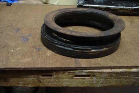 1993 Ford Bronco - Close-up of a worn pulley or bearing seal resting on a wooden surface.