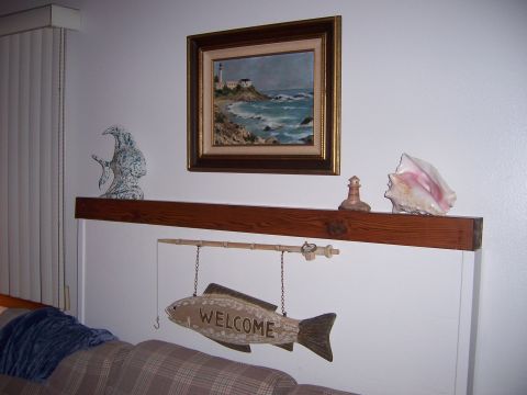 1991 Ford Bronco - A decorative fish sign hangs below a painting of a coastal scene.