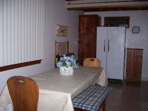 1991 Ford Bronco - A dining area scene a table set with a vase of flowers, chairs, a bench, and various kitchen appliances and cabinetry.